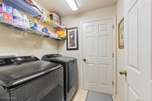 clothes washing area with light tile patterned floors and independent washer and dryer