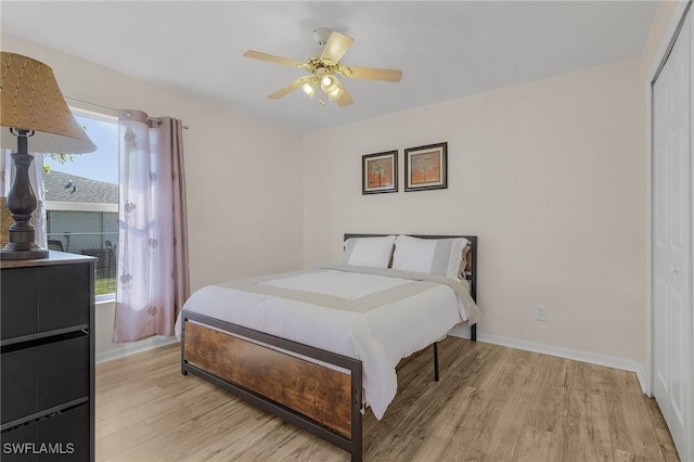 bedroom with ceiling fan, light wood-type flooring, and multiple windows