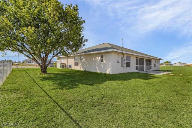 back of property with a lawn and a patio