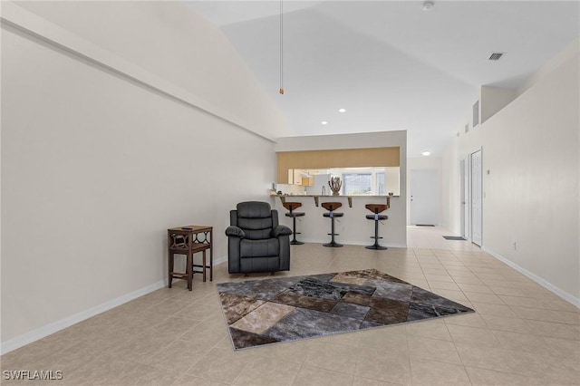 living area featuring light tile patterned floors and high vaulted ceiling