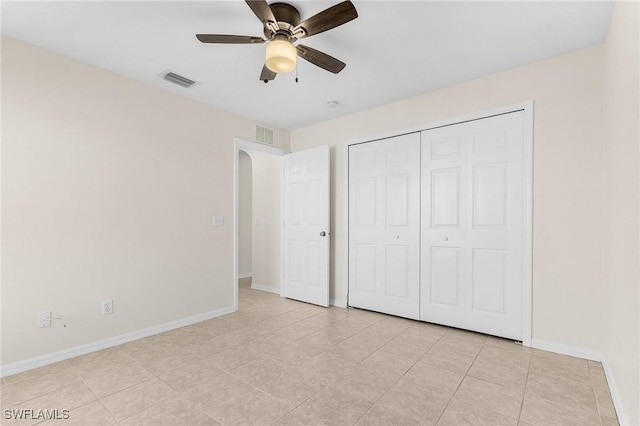 unfurnished bedroom featuring ceiling fan, light tile patterned floors, and a closet