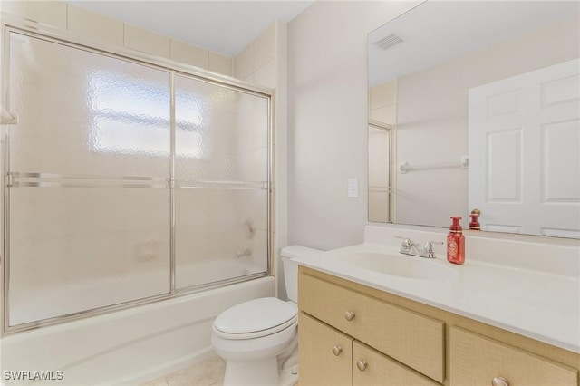 full bathroom featuring toilet, tile patterned flooring, enclosed tub / shower combo, and vanity