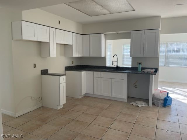 kitchen featuring white cabinetry, sink, and light tile patterned floors