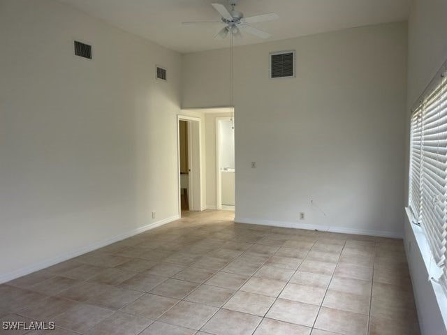 spare room featuring ceiling fan and light tile patterned floors