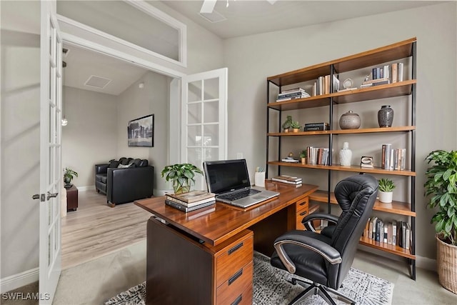 office space featuring vaulted ceiling, light hardwood / wood-style floors, and french doors