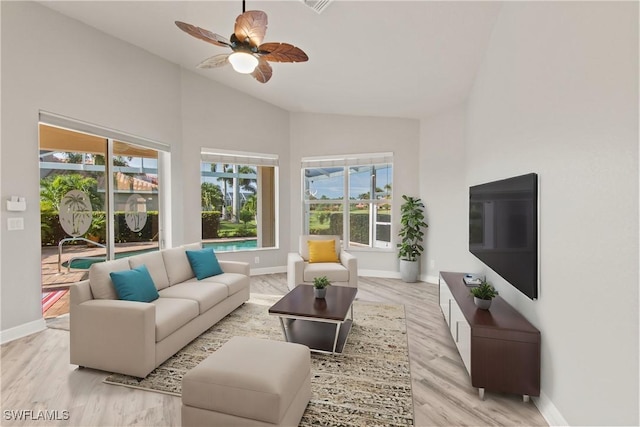 living room featuring ceiling fan, high vaulted ceiling, and light hardwood / wood-style flooring