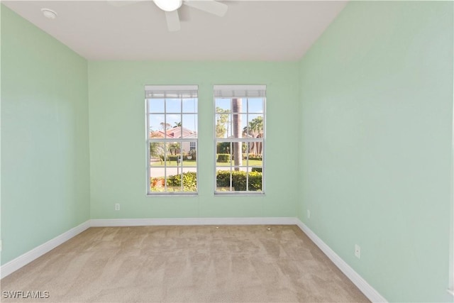 carpeted spare room featuring ceiling fan