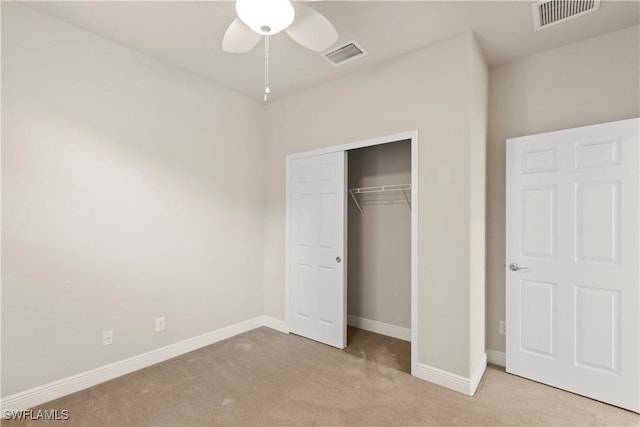 unfurnished bedroom with ceiling fan, a closet, and light carpet