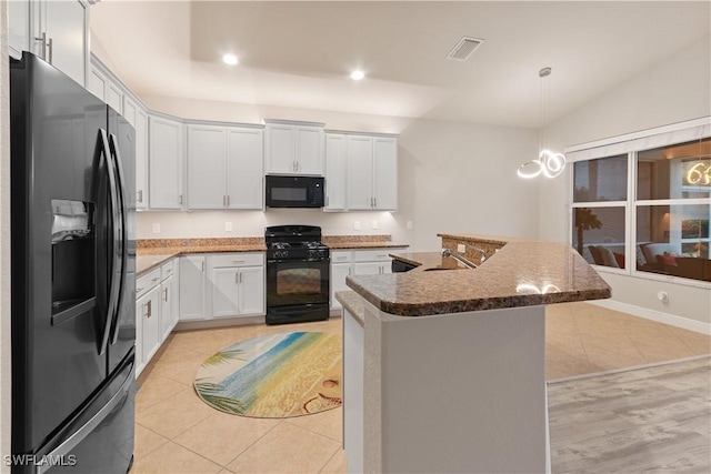 kitchen with sink, white cabinetry, decorative light fixtures, a kitchen island with sink, and black appliances