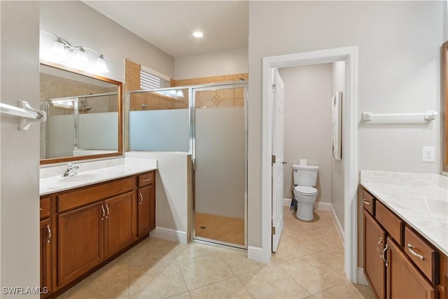 bathroom featuring vanity, tile patterned flooring, toilet, and walk in shower