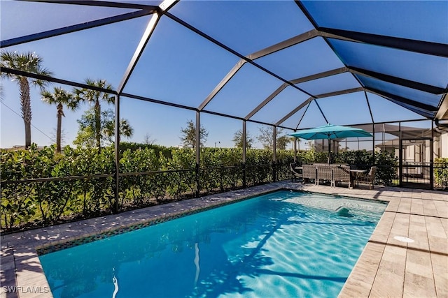 view of swimming pool featuring a patio and glass enclosure