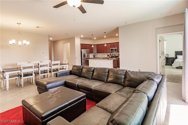 tiled living room featuring ceiling fan with notable chandelier