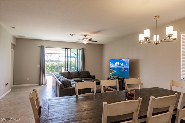 dining space with ceiling fan with notable chandelier and light tile patterned flooring