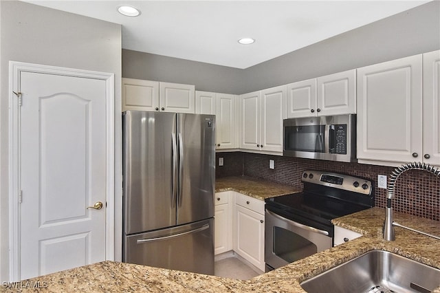 8681 Athena Ct, Lehigh Acres, FL 33971 - kitchen featuring appliances with stainless steel finishes, a sink, stone counters, white cabinetry, and recessed lighting