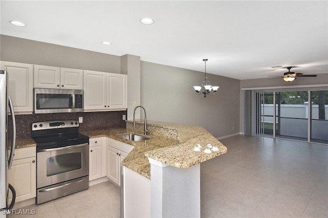 8681 Athena Ct, Lehigh Acres, FL 33971 - kitchen with stainless steel appliances, a sink, a peninsula, tasteful backsplash, and light tile patterned flooring