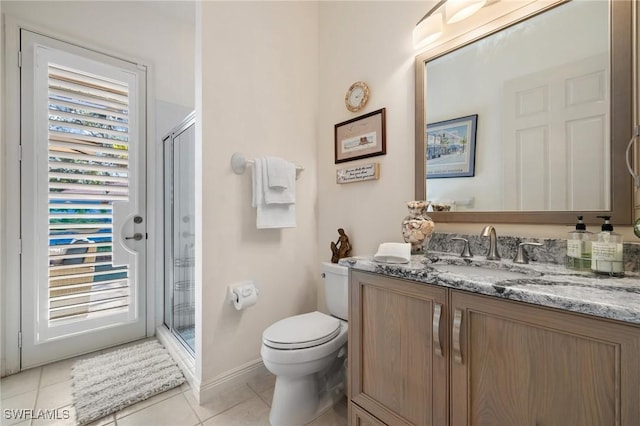 bathroom with toilet, a shower with door, tile patterned floors, and vanity