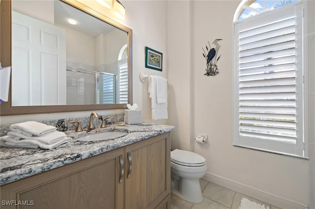 bathroom featuring a shower with door, vanity, tile patterned floors, and toilet