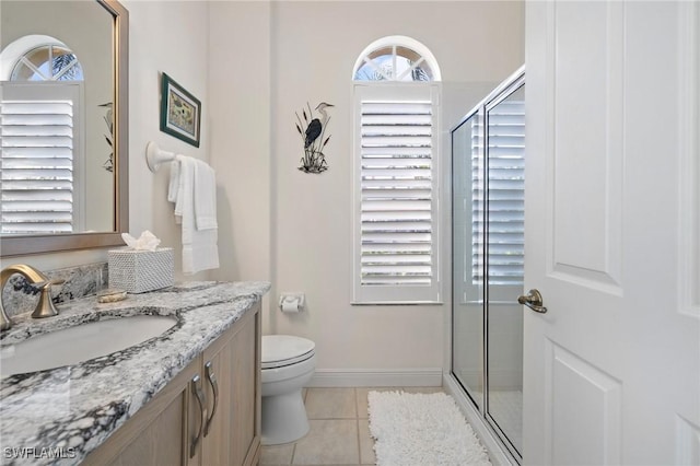 bathroom with toilet, an enclosed shower, tile patterned floors, and vanity