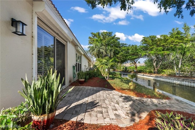 view of yard featuring a water view and a patio area