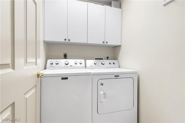 laundry room featuring cabinets and washer and dryer