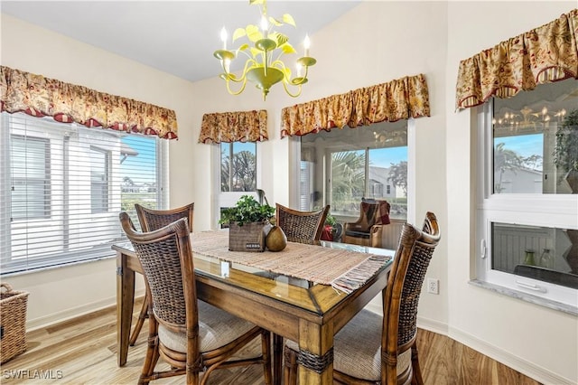 dining room with light wood-type flooring and a notable chandelier