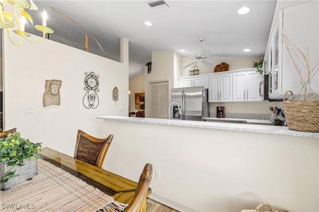 kitchen with stainless steel refrigerator with ice dispenser, ceiling fan, stove, lofted ceiling, and white cabinets