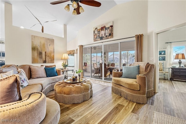 living room with ceiling fan, lofted ceiling, and light wood-type flooring