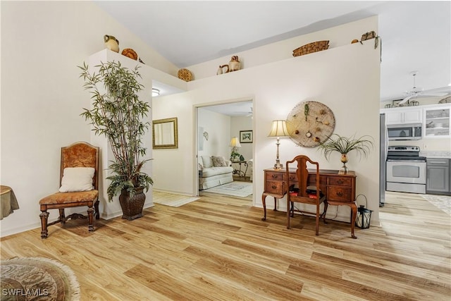 living area featuring light wood-type flooring, ceiling fan, and lofted ceiling