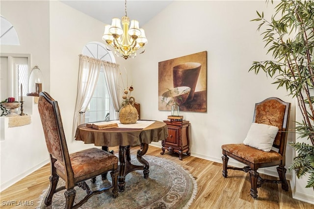 dining area featuring high vaulted ceiling, an inviting chandelier, and light hardwood / wood-style floors