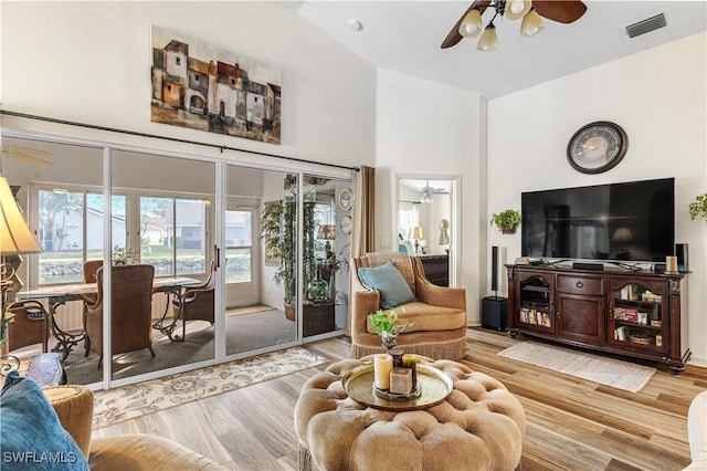 living room featuring ceiling fan, wood-type flooring, and vaulted ceiling