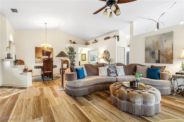 living room with lofted ceiling, ceiling fan with notable chandelier, and light hardwood / wood-style floors