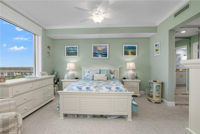 carpeted bedroom featuring ensuite bathroom, ceiling fan, and ornamental molding