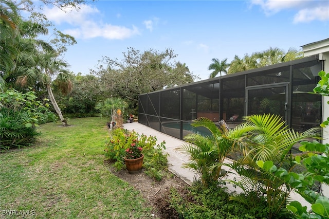 view of yard featuring a swimming pool with hot tub, a patio, and glass enclosure