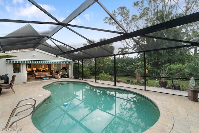 view of pool with a patio area and glass enclosure