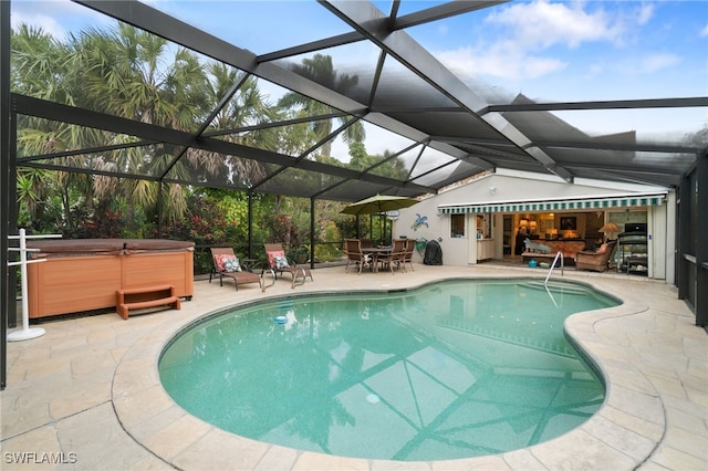 view of swimming pool featuring a patio, a hot tub, and glass enclosure