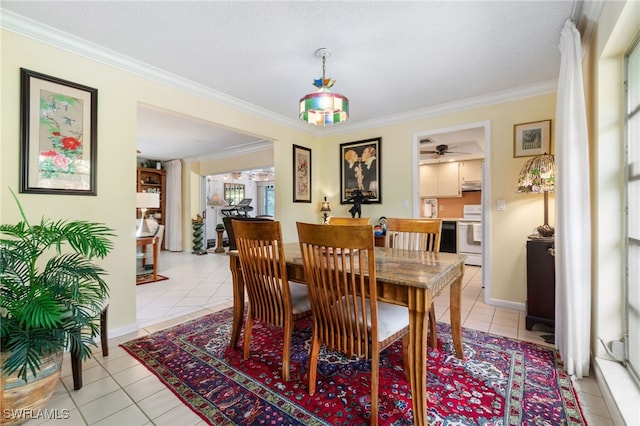 dining space with light tile patterned floors and ornamental molding