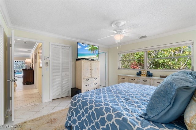 bedroom featuring light tile patterned flooring, ceiling fan, crown molding, and a textured ceiling