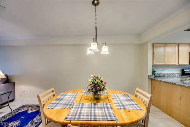 dining area featuring light tile patterned floors, an inviting chandelier, and ornamental molding