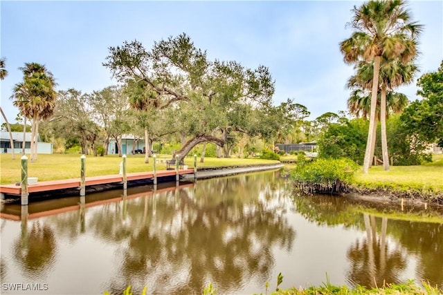 dock area with a lawn and a water view