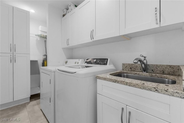 laundry area featuring cabinets, washing machine and dryer, sink, and light tile patterned floors