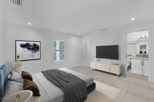 bedroom with light tile patterned flooring, connected bathroom, and sink