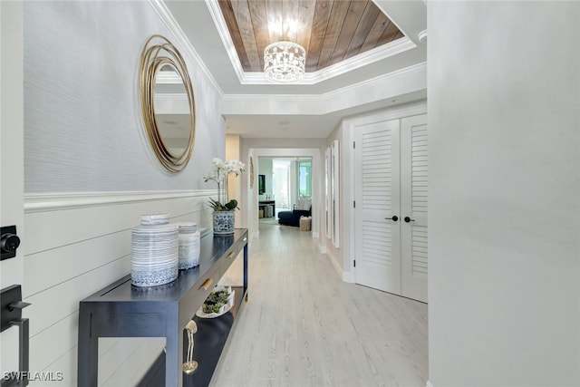 hall featuring wooden ceiling, an inviting chandelier, ornamental molding, and light hardwood / wood-style floors