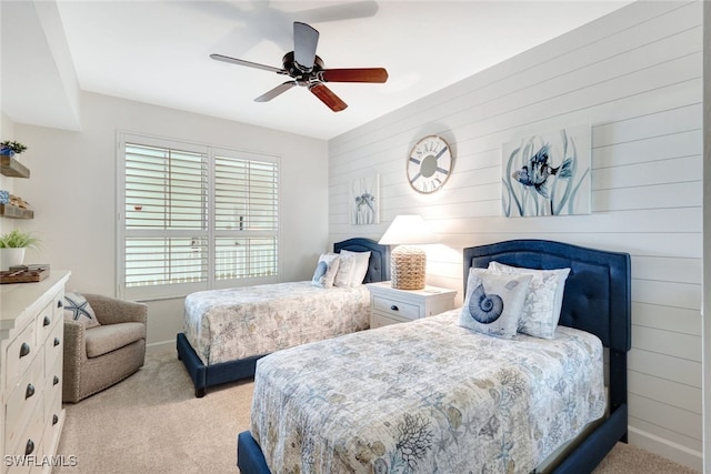 carpeted bedroom with ceiling fan, wooden walls, and multiple windows