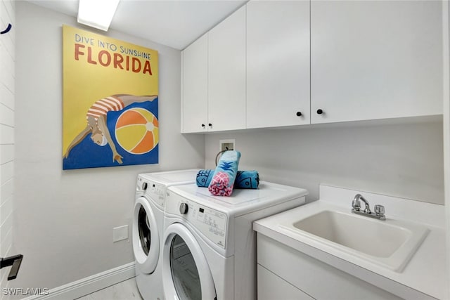 laundry room with sink, independent washer and dryer, and cabinets