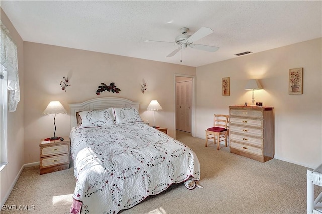 bedroom with a closet, ceiling fan, a textured ceiling, and light carpet