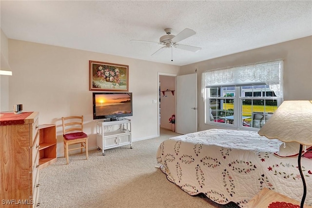 carpeted bedroom featuring a textured ceiling, a closet, ceiling fan, and a walk in closet