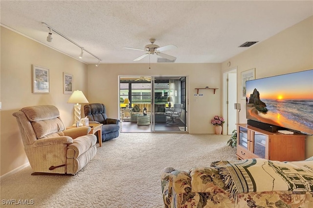 living room with carpet floors, a textured ceiling, track lighting, and ceiling fan