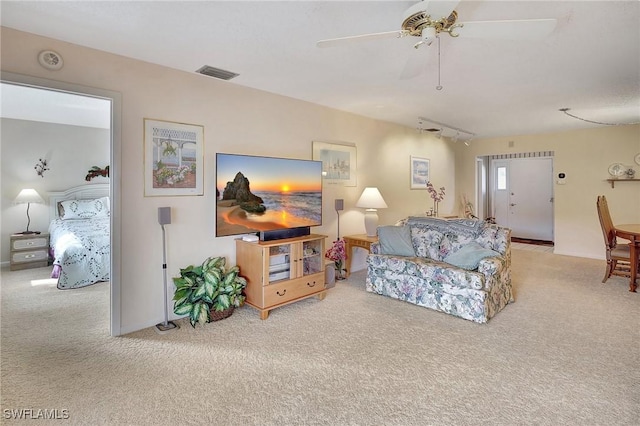 living room featuring ceiling fan, light colored carpet, and track lighting