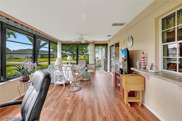 sunroom / solarium featuring ceiling fan