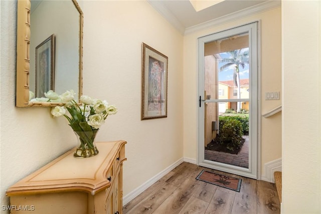 entryway with ornamental molding and light hardwood / wood-style floors